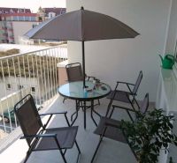 Balcony of a 3-room apartment Above the Beach in Banská Bystrica with seating and a sunshade.