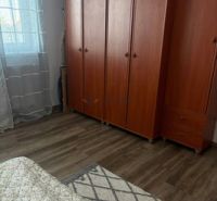 A room in a 2-room apartment with wardrobes and a floor with a wooden decor.