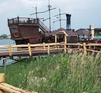 A wooden boat as an attraction at the cottage on the Senec Lakes, behind a wooden fence.