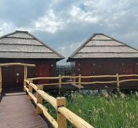 Wooden cabins above the water surface with thatched roofs at Senec Lakes.