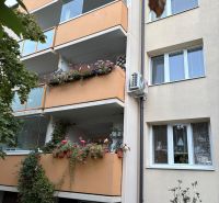 An apartment building with balconies full of flowers on Za hradbami Street in Pezinok.