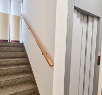 Staircase with railing and elevator in a building near a 3-room apartment.