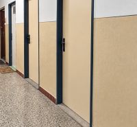 A hallway with a trio of doors in a building, a floor with a stone pattern.