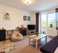 Living room in a 3-room apartment with comfortable seating and access to a balcony.
