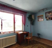 Blue room with a window, table, and chair in a family house.