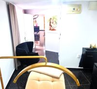 Commercial space with a cosmetic bed, black chairs, and white walls.
