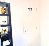 Interior of commercial premises with a door to the toilet and a decorative shelf.