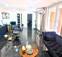 Commercial space with black furniture, an armchair, and decorative elements, floor with a dark decor.