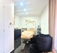 Interior commercial spaces with a sofa set, mirror, and gold accessories.