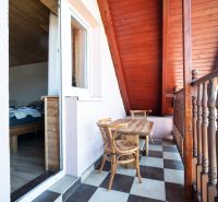 A balcony with a wooden table and a view from hotels and guesthouses in Liptovský Michal.