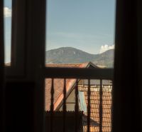 View from the window of rooftops and mountains in Liptovský Michal, hotels and guesthouses.