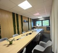 Conference room in a building with a wood-patterned floor and a long table.