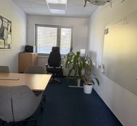 The interior of an office with a whiteboard, conference table, and projector on the wall of the building.
