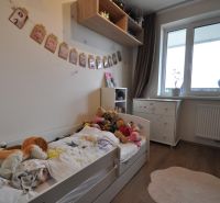Children's room in a three-room apartment with a wooden decor floor and a window.