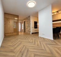 A kitchen with a dining area and a wooden decor floor in a 3-room apartment.