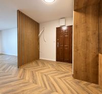 Interior of a 3-room apartment with a wooden decor floor and a wooden wall.