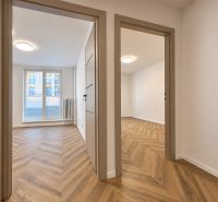 Interior of a 3-room apartment with a wooden decor floor and plenty of natural light.