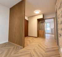 Interior of a 3-room apartment with a brick wall and a floor with a wooden decor.