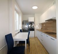 A kitchen with a table and a wooden decor floor in a 2-room apartment.