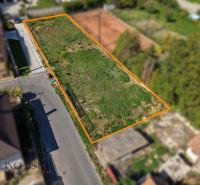 A plot for residential use in Dunajská Streda in Malý Blahovo, bordered by a road and greenery.