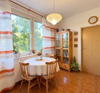 A clear kitchen in a 3-room apartment with a wooden decor floor and a dining table.