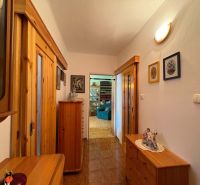 A hallway in a 3-room apartment with a wooden decor floor and wooden furniture.