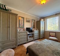 A bedroom with pistons, decorative cabinets, and a wooden decor floor in a 3-room apartment.