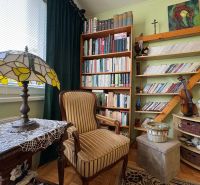 A library with many books and decorations in a 3-room apartment, a floor with a wooden decor.