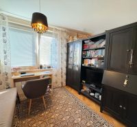 A workspace with a desk, chair, and cabinets, 3-room apartment, floor with wood decor.