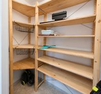 Storage space with shelves and a vacuum cleaner in a 2-room apartment.