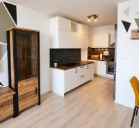 A kitchen in a 2-room apartment with geometric patterns and a wooden decor floor.