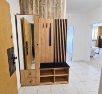 Entrance hallway with wooden furniture and tiles in a 2-room apartment.