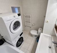 Bathroom with appliances and sanitary ware in a 2-room apartment, ceramic tiles and flooring.