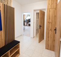 Hallway with a coat rack and entrance to the living room in a 2-room apartment, wooden decor.