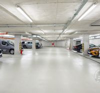 Underground garages with marked parking spaces and parked cars.