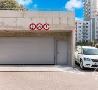 Garages on Bosákova Street in an area with apartment buildings and parked cars.