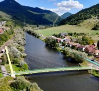 Panorama of the town of Švošov with green hills and a river for residential plots.