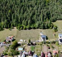 Aerial view of residential plots in Švošov surrounded by forest.