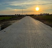 A paved road in Vinohrady in Senica at dusk with a view of the city.