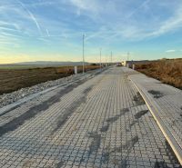 A road with a paved surface in Vinohrady, Senica, the surrounding landscape, and lighting poles.