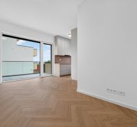 Living room in a three-room apartment with a wooden decor floor and a balcony.