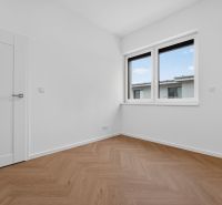 A room in a 3-room apartment with a window and a floor with a wooden decor.