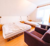 A room in a family house, bed, armchair, desk, floor with wooden decor.