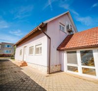 A family house on Nova Street in Podhájska with a red roof and a paved walkway.
