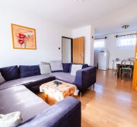 Living room with a dark sofa and a wooden decor floor in a family house.
