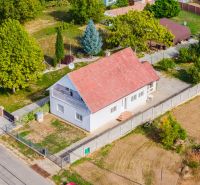 A family house on Nová Street in Podhájska surrounded by greenery and fields, with a terrace.