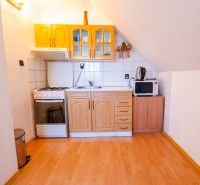 A kitchen in a family house with a wooden decor floor and a stove.