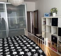 Bedroom in a 2-room apartment with storage space, bed, and floor with wooden decor.