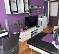 Living room in a two-room apartment with a sofa and furniture, floor with wooden decor.