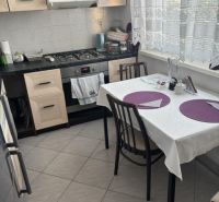 Kitchen in a 2-room apartment with a dining table and a kitchen unit.